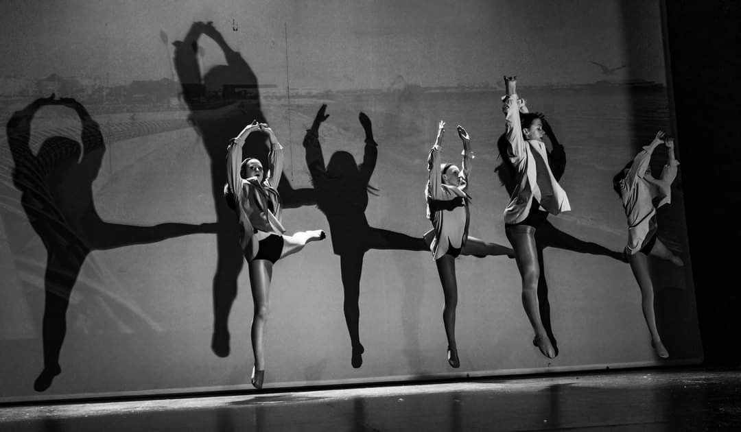 Black and white silhouettes of dancers in a studio